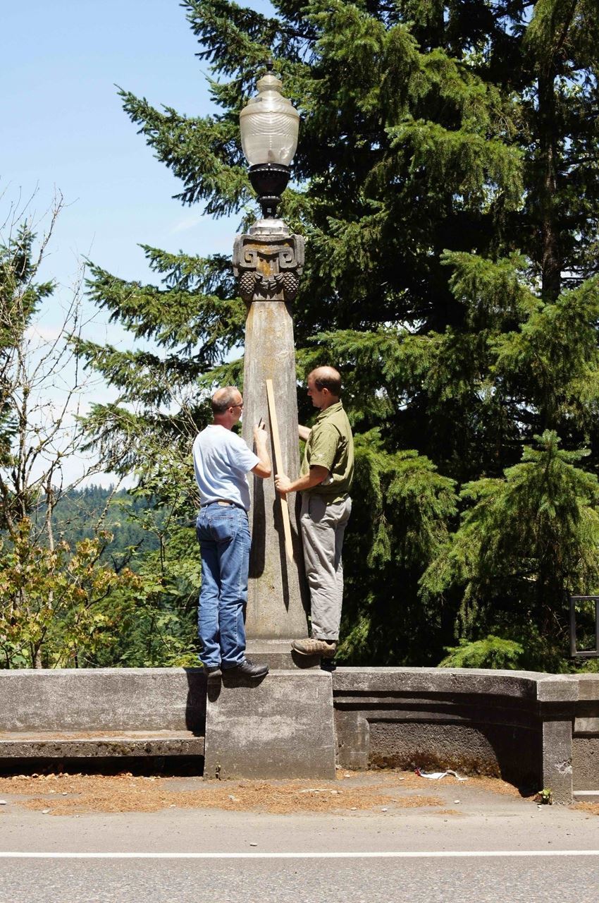 Chris Bell (right), with bridge preservation engineer, Mats Halvordson, evaluating what Chris believes is Pacific Northwest take on the Corinthian Order, "The Pineconian." They recorded and subsequently replicated this light post to replace ones removed during WWII on a bridge near Crater Lake. A free signed ODOT Historic Bridge Field Guide (at the San Antonio Conference) to the first VAN reader who can identify the location. Photo courtesy of Chris Bell.